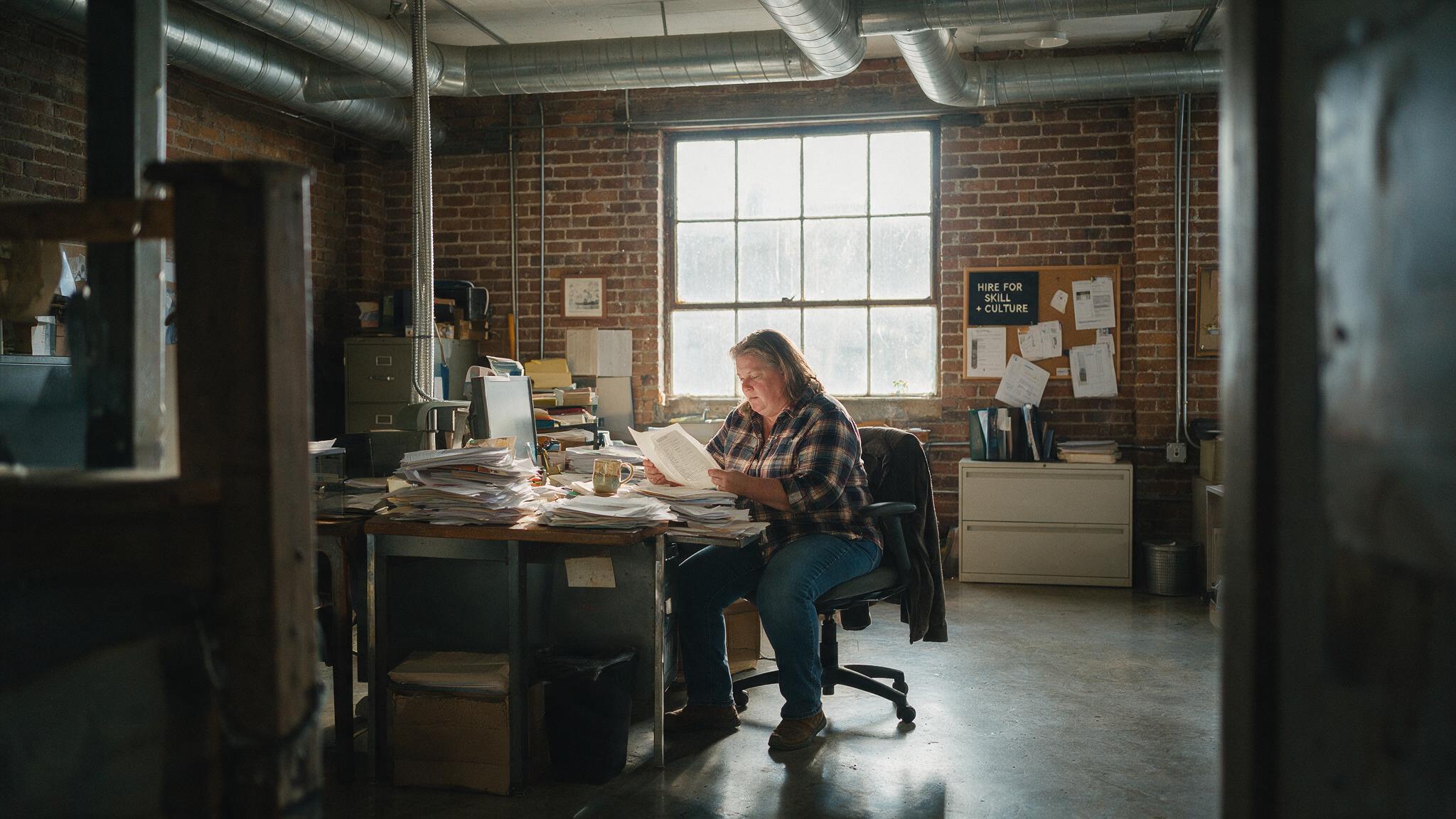 Hiring manager reviewing resumes at desk